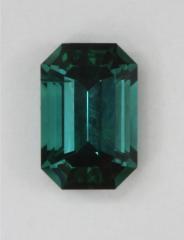 Open ended blue emerald cut with shift to blue green in yellow light.