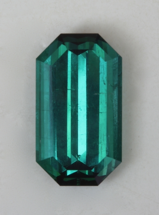 Slightly included, bright blue green, semi closed ends, emerald cut
