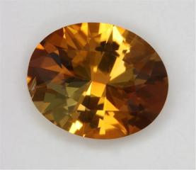 Modest golden tourmaline darkened with brown oval
