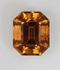 A beautiful yellow orange fully cut emerald cut.