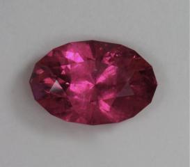 Moderately heavy inclusion in a really rich, hot pink oval