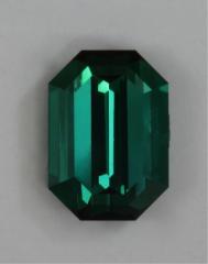 Smaller, blue green, emerald cut with steep ends.