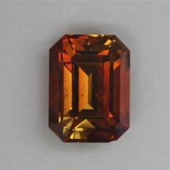 Included dichroic golden red brown emerald cut.