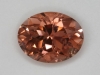 A modest, slightly included, pink, peach, golden oval.