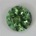 Lightly included, medium toned green with a spec of blue, round. #724