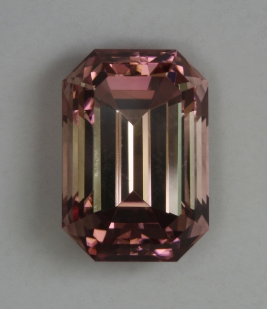 Nice peach with a pink shadow emerald cut.