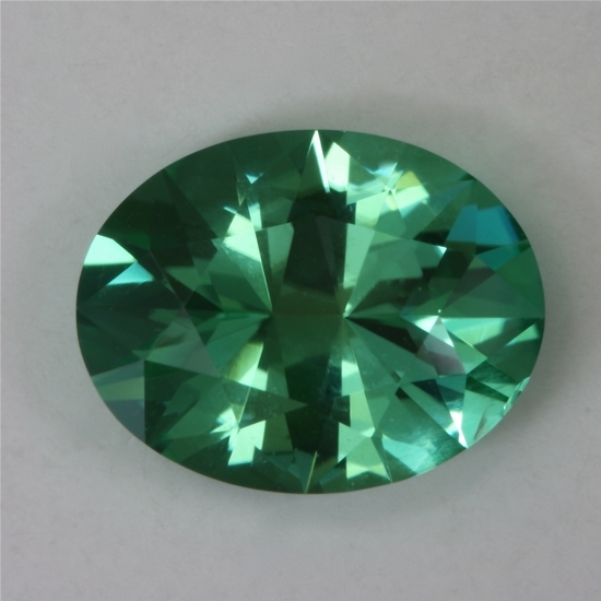 Bright, eye clean slightly dichroic blue green oval.