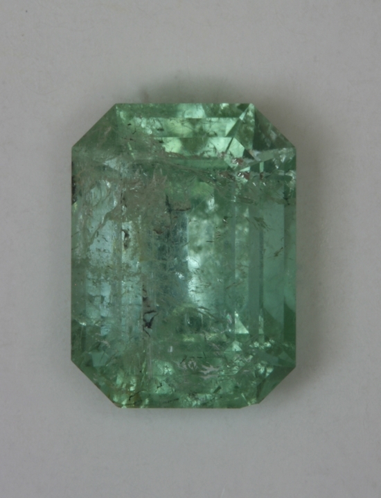 Heavily included minty green emerald cut Brazil