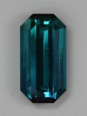 Flawed, medium dark toned, saturated blue emerald cut.  #391