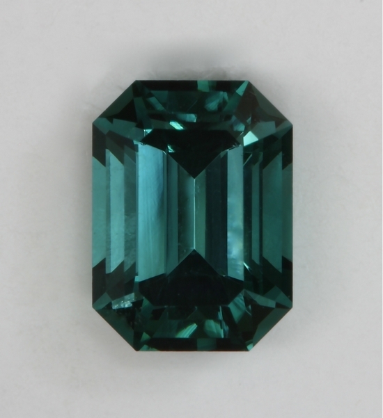 Slight dichroic medium toned blue with touch of gray emerald cut.  #430